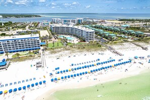 A resort with multiple buildings, a beach with umbrellas, and a pool area. - Beautiful DW Gulfside 403 (Fort Walton Beach)