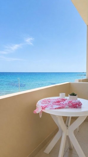 A balcony with a table, a potted plant, and a view of the sea. - Casa Del Mare (Kokkini Chani)