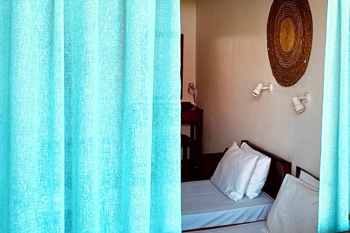 Une pièce comprenant un lit, un élément de décoration circulaire fixé au mur et une petite table avec une lampe.