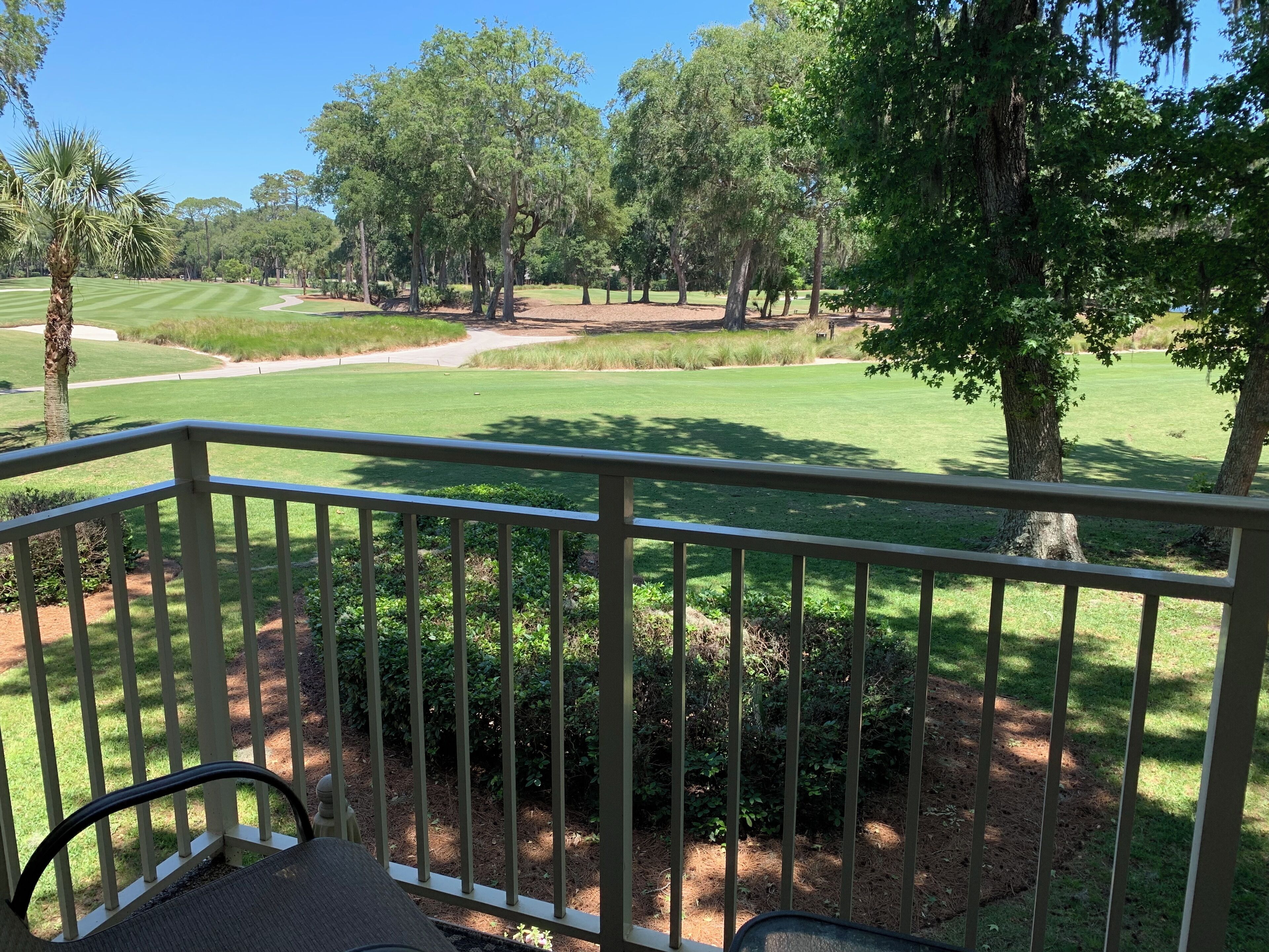 Vista desde un balcón sobre un campo de golf con árboles y un césped cuidado.