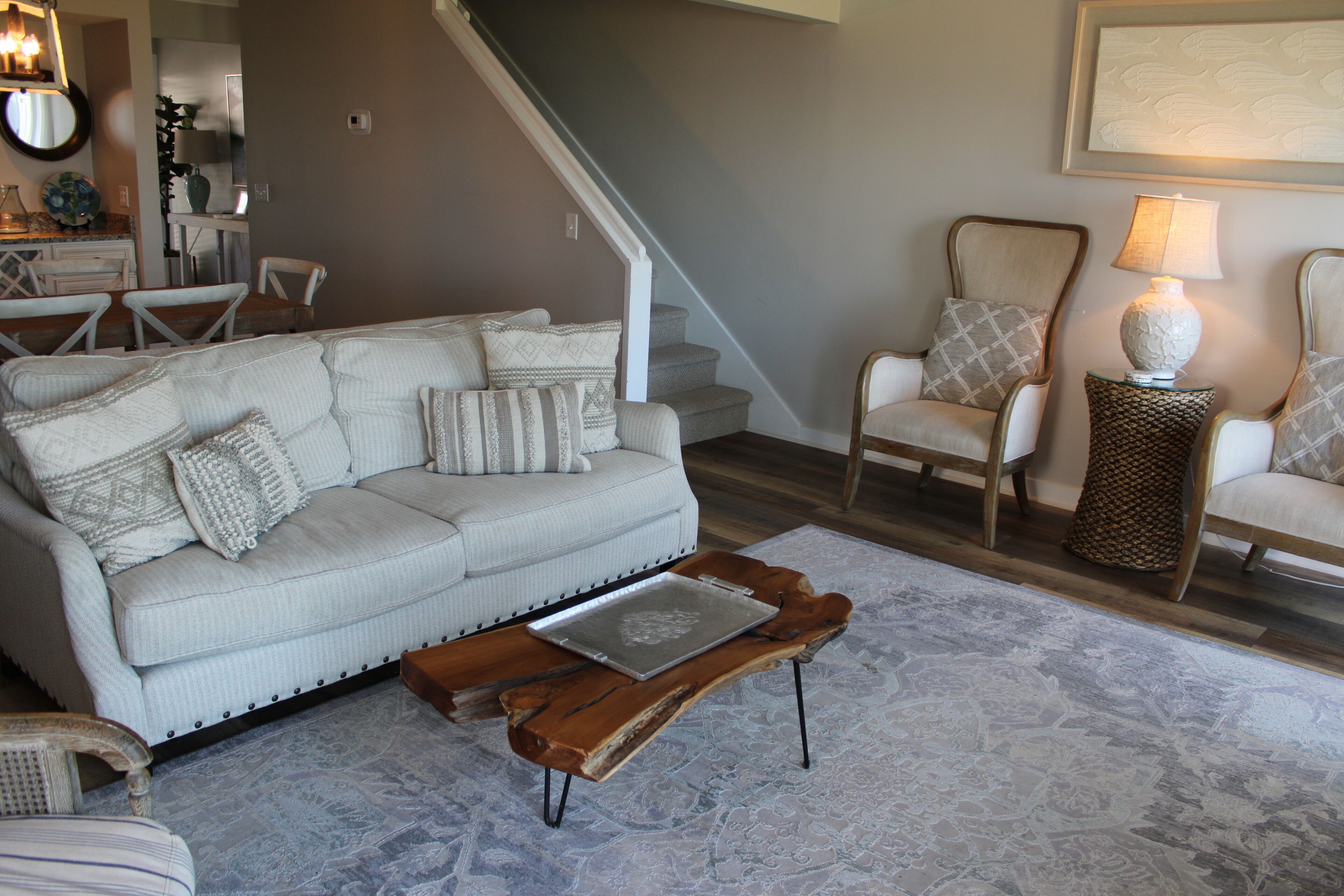 A living room with a sofa, chairs, a coffee table, and a lamp.