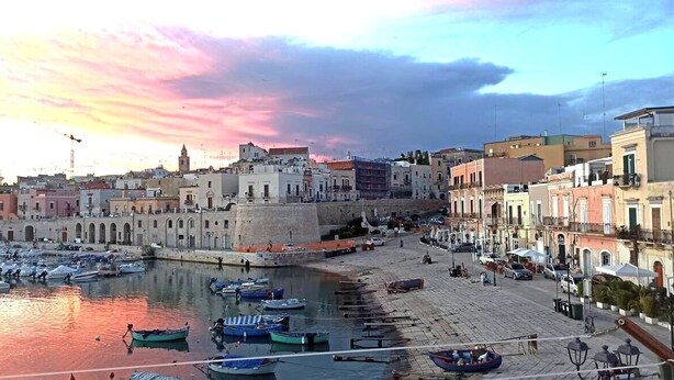 A coastal town with historic buildings, a marina with boats, and a waterfront promenade. - Iris Apartment - comfort e stile (Bisceglie)
