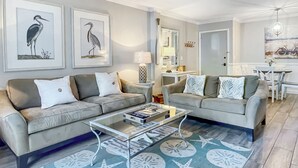 A modern living room with two sofas, a coffee table, and a dining area with a table and chairs. - 870 Ketch Court at The Sea Pines Resort (Hilton Head Island)