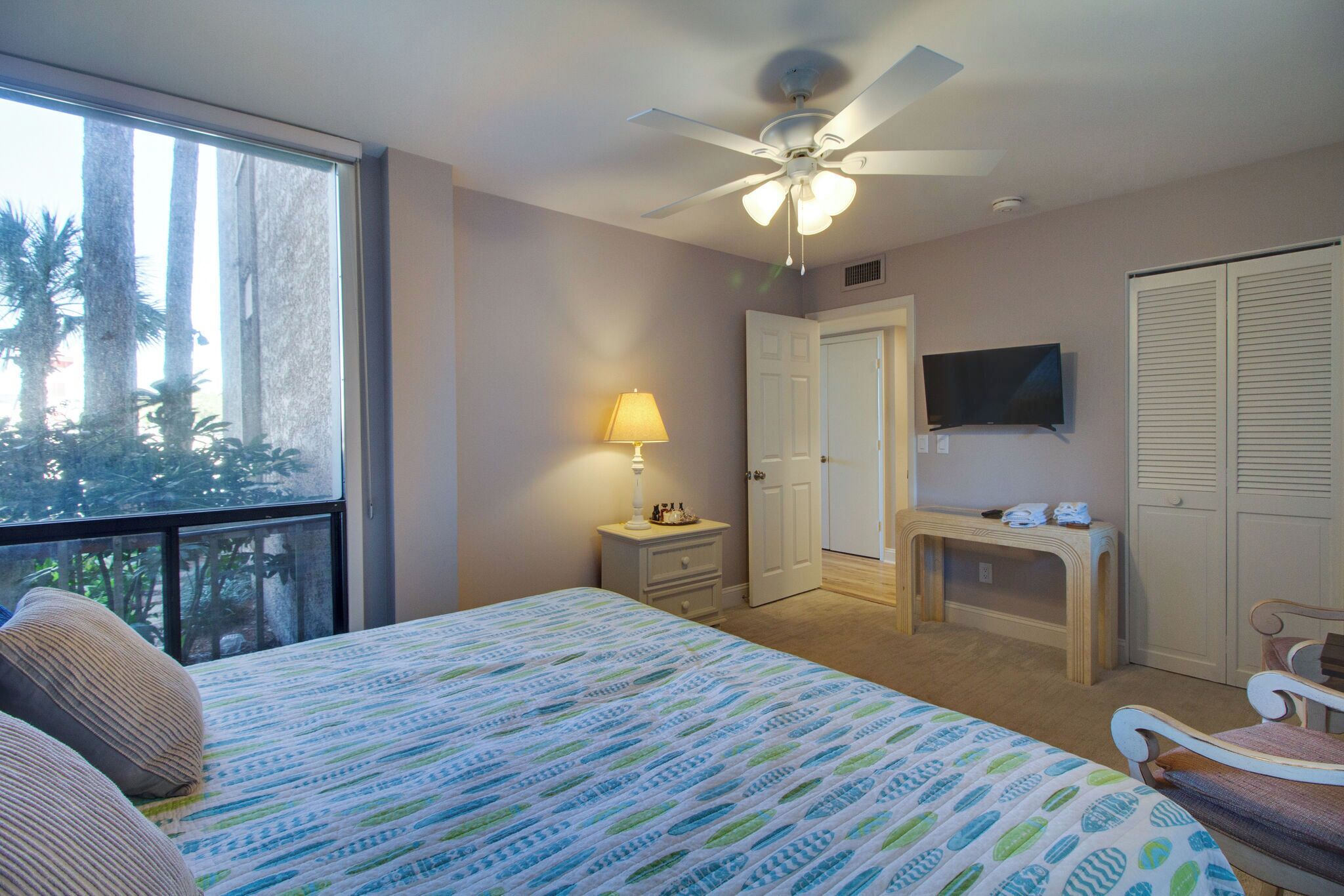 A bedroom with a bed, a desk, a television, and a wardrobe.