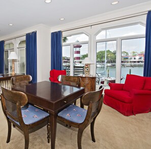A dining area with a table, chairs, and a red sofa. - 1116 Harbour South Club Villa at The Sea Pines Resort (Hilton Head Island)