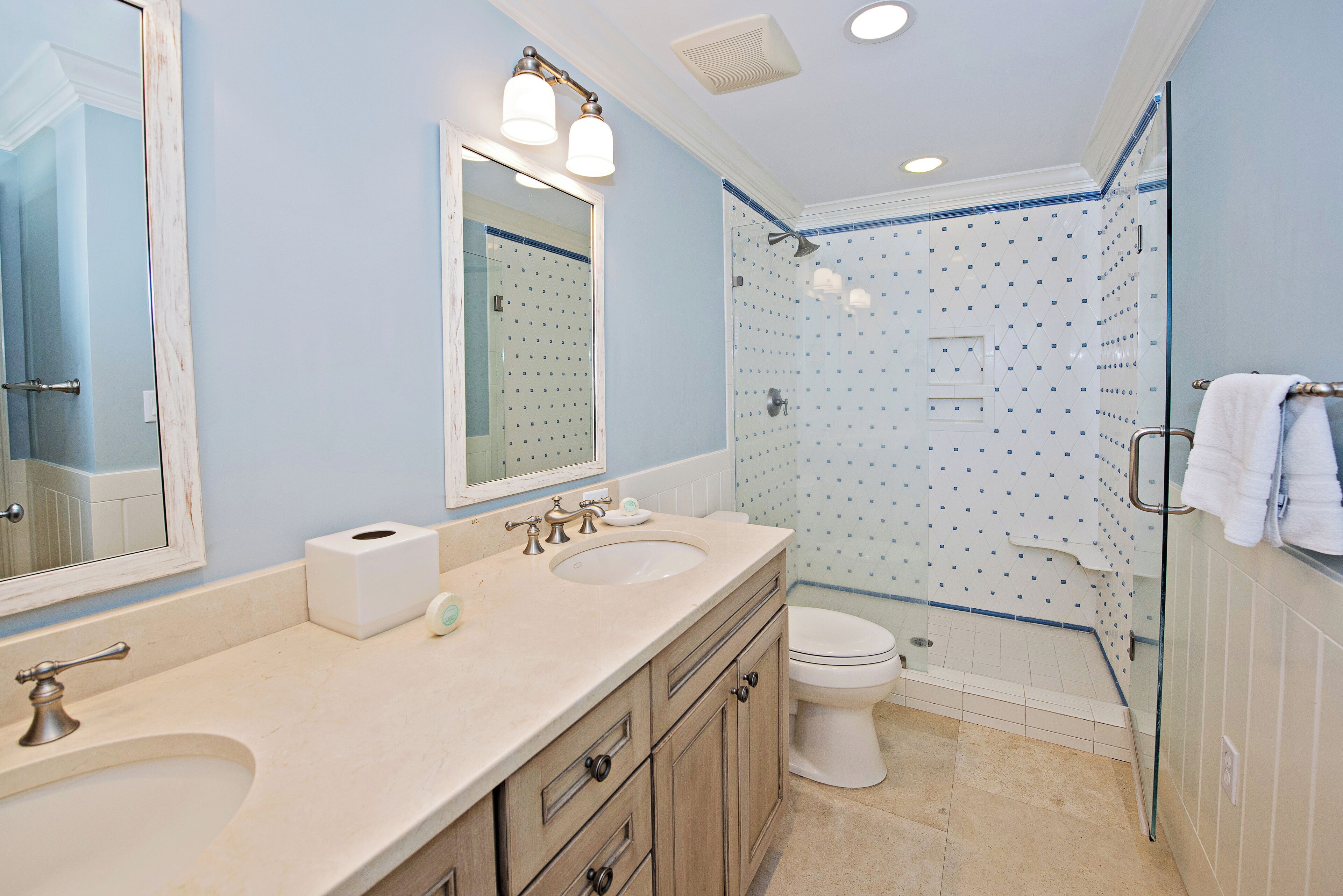 A bathroom with two sinks, a toilet, and a shower area.