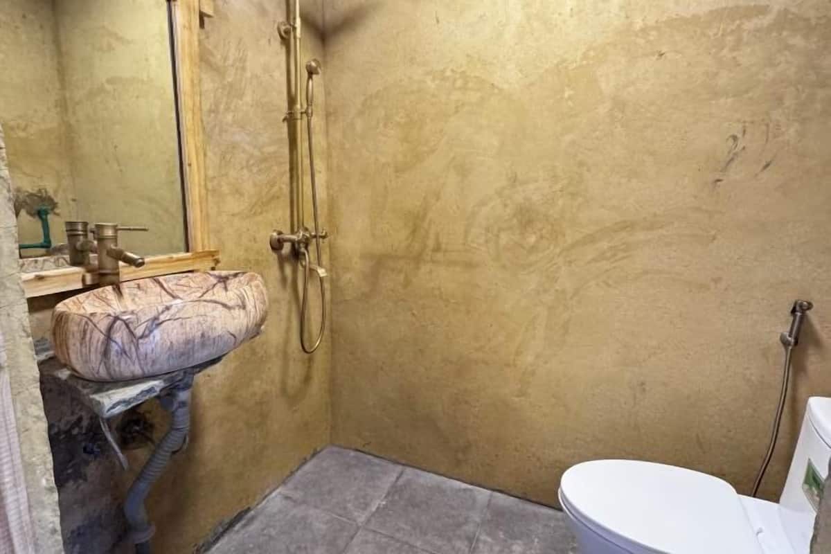 A small bathroom with a toilet, a sink, and a shower.