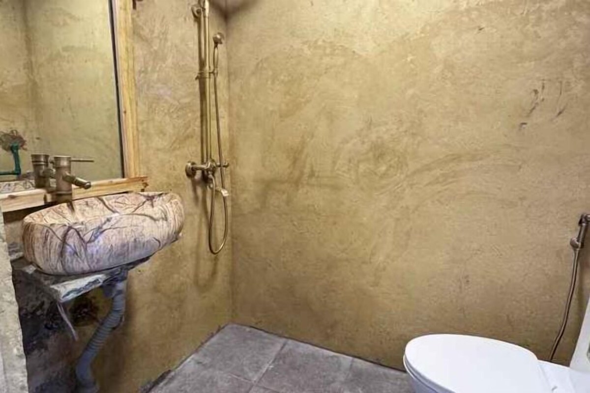 A small bathroom with a shower, a toilet, and a sink.