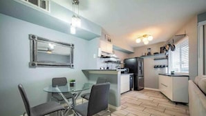 Una cocina compacta con zona de comedor, un refrigerador y un horno empotrado.