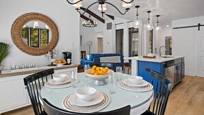 A modern kitchen with white cabinetry, a blue accent wall, and a dining area with a round table set for six. - 1590 Lagoon Villas at The Sea Pines Resort (Hilton Head Island)