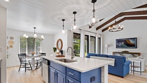 A modern kitchen with a central island, blue cabinets, and pendant lighting. - 1590 Lagoon Villas at The Sea Pines Resort (Hilton Head Island)