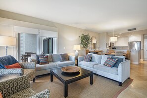 A spacious living area with a light blue sofa set, a dark coffee table, and patterned armchairs. - 1857 Beachside Tennis at The Sea Pines Resort (Hilton Head Island)