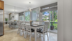 A modern kitchen with a dining area, large windows, and a view of the outdoors. - 1261 Harbour Town Club at The Sea Pines Resort (Hilton Head Island)
