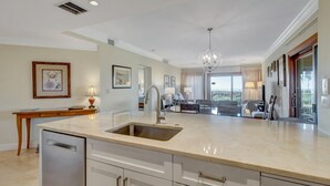 A modern kitchen with a large island, stainless steel appliances, and a view to the living area. - 1868 Beachside Tennis at The Sea Pines Resort (Hilton Head Island)