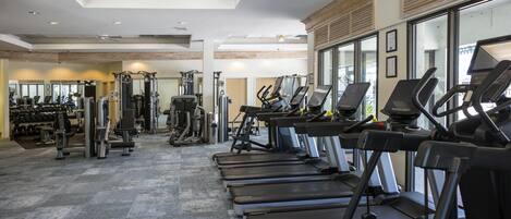 A gym with treadmills, weight machines, and free weights.