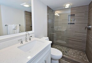 A modern bathroom with a glass-enclosed shower, a white sink, and a toilet. - 1255 Harbour Town Club at The Sea Pines Resort (Hilton Head Island)