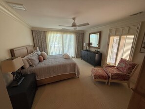 A bedroom with a bed, a dresser, a chair, a ceiling fan, and a window with blinds. - 2001 Turtle Lane at The Sea Pines Resort (Hilton Head Island)