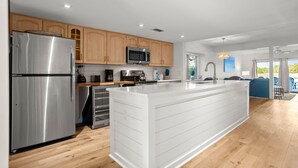 A modern kitchen with wooden cabinets, stainless steel appliances, and a large island. - 1619 Port Villas at The Sea Pines Resort (Hilton Head Island)
