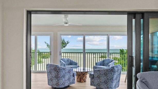 A balcony with a view of the ocean, furnished with two chairs and a table. - Gulf-Front 3BR Sanibel Condo with Stunning Views! (Sanibel)
