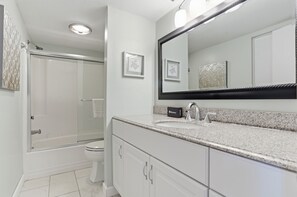 A modern bathroom with a shower, toilet, and vanity with a large mirror. - 2303 Heritage Villas at The Sea Pines Resort (Hilton Head Island)