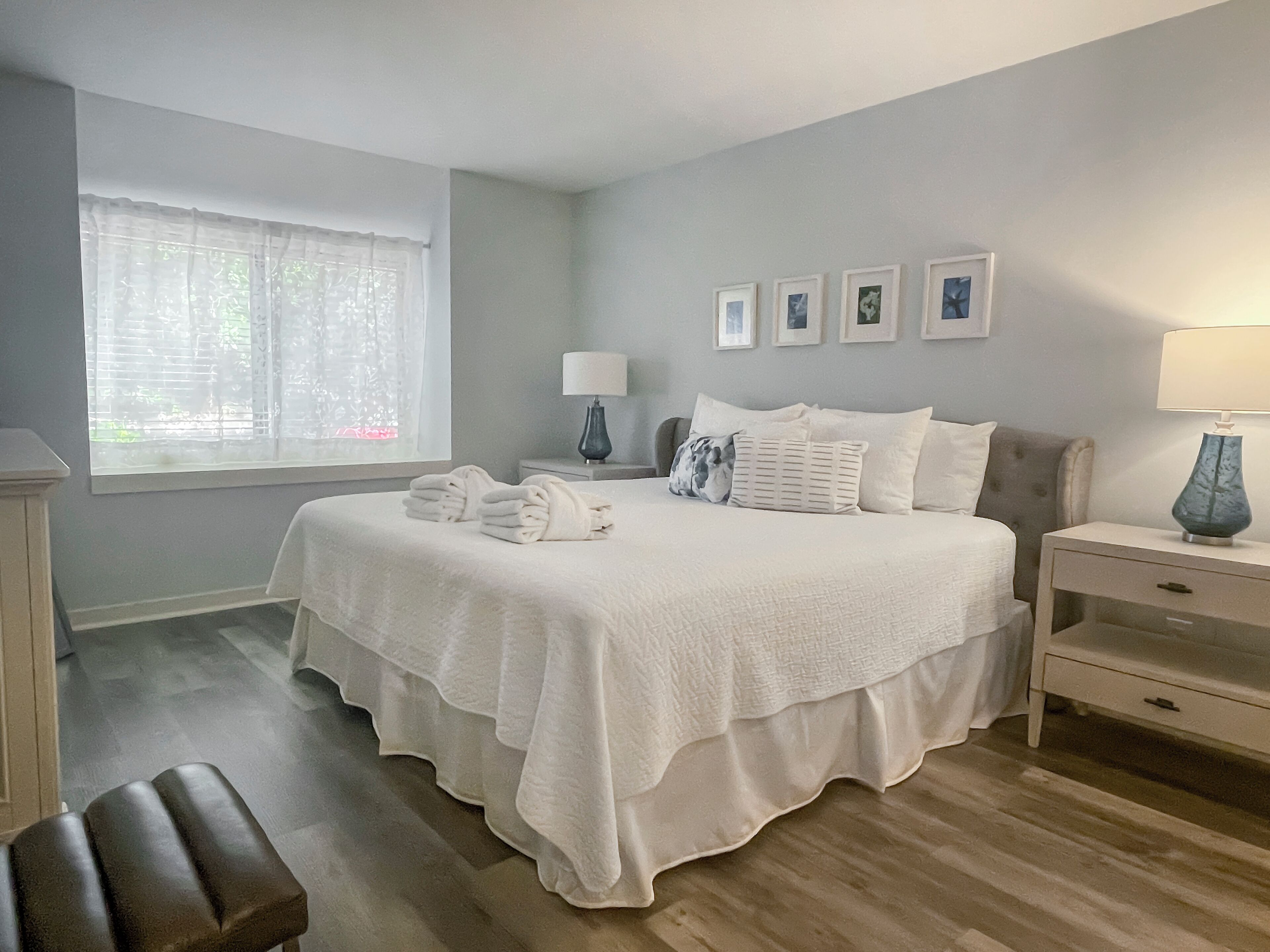 A bedroom with a bed, bedside tables, a chair, and a window with curtains.
