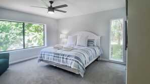 A bedroom with a bed, a ceiling fan, and large windows. - 2244 Heritage Villas at The Sea Pines Resort (Hilton Head Island)