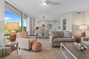 Un salon moderne comprenant un canapé, des fauteuils, une table basse et un coin repas avec une table et des chaises.