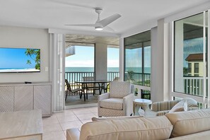 Ein geräumiger Balkon mit Meerblick, einem Deckenventilator und einem Essbereich mit Stühlen und Tisch.