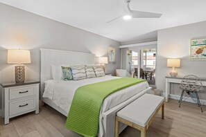 Une chambre à coucher avec un lit, des tables de chevet, un bureau et une chaise.