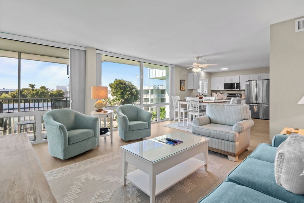 A modern apartment with a spacious living area, a kitchen, and large windows offering a view of the city.