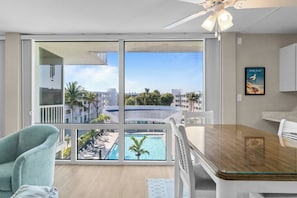 Una habitación moderna con un amplio ventanal con vistas a una piscina y edificios.