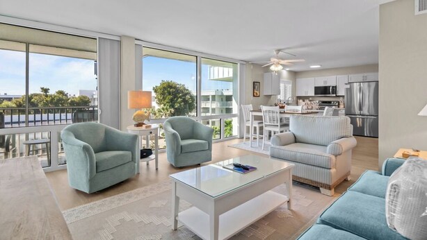 Un apartamento moderno con un amplio salón, cocina y grandes ventanales que ofrecen vistas a la ciudad.