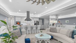 Een moderne woonkamer met een bank, salontafel en een eethoek met stoelen.