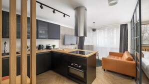 Ett modernt kök med en central köksö, en inbyggd ugn och ett stort fönster.