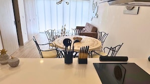 A modern kitchen with a central island, dining table, and chairs. There is a built-in oven and a dishwasher. - Chipipe House, Salinas (Salinas)
