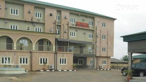 A multi-story building with a sign reading "LEKSOKKY HOTEL & SUITES". - Lekosokky  Hotel and Suites (Ijoko)
