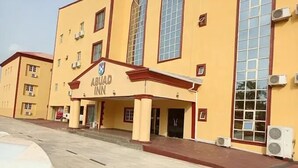 Un edificio con un letrero que dice "ABUAD INN" y varias unidades de aire acondicionado en el exterior.