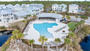 A resort with a large pool, multiple buildings, and a surrounding natural landscape. - Sugar Shores at Summer Salt (Orange Beach)