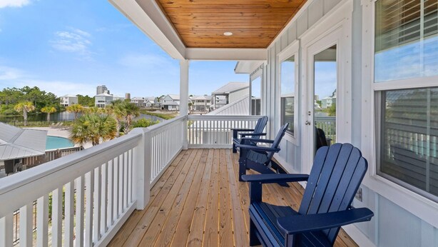 A wooden deck with white railings and blue Adirondack chairs. - Sugar Shores at Summer Salt (Orange Beach)