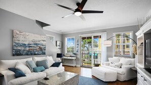 A modern living room with a white sofa, a coffee table, and a TV stand.