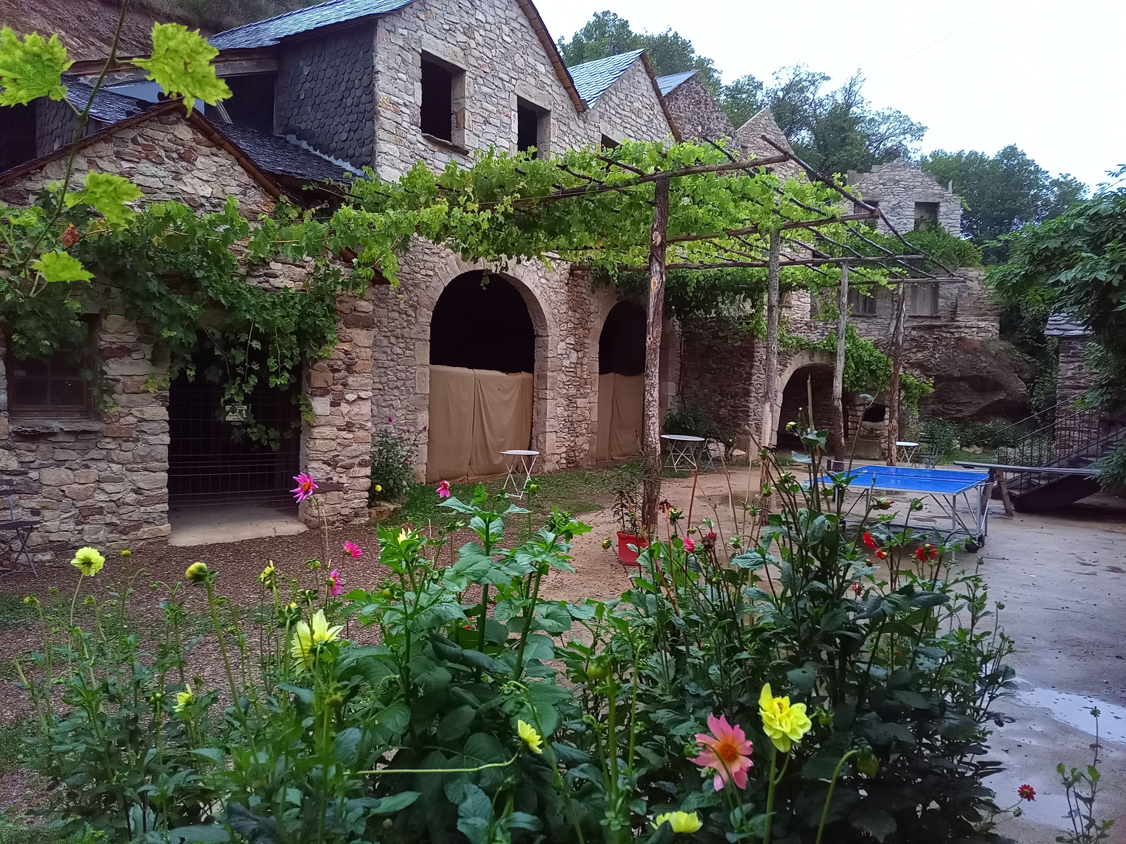 A stone building with arched windows and a covered outdoor area.