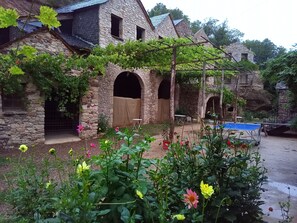 Ein Steinhaus mit Bogenfenstern und einem überdachten Außenbereich.