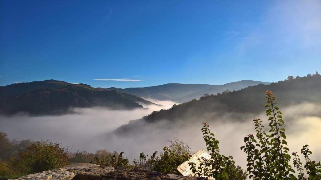 A mountainous landscape with a valley and mist-covered hills.