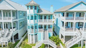 A coastal building with multiple balconies, staircases, and a tower-like structure. - Pet Friendly, Easy Walk to Beach, Game Room, Beach Toys, Gorgeous Community (Galveston)