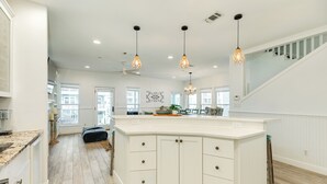 A spacious kitchen with a large island, white cabinetry, and pendant lighting. - Pet Friendly, Easy Walk to Beach, Game Room, Beach Toys, Gorgeous Community (Galveston)