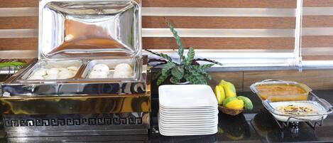 A buffet setup with a variety of food items and serving dishes.