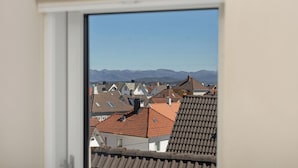 A view from a window overlooking a residential area with houses and mountains in the distance. - Central Guest House - Private Bathroom (Stavanger)