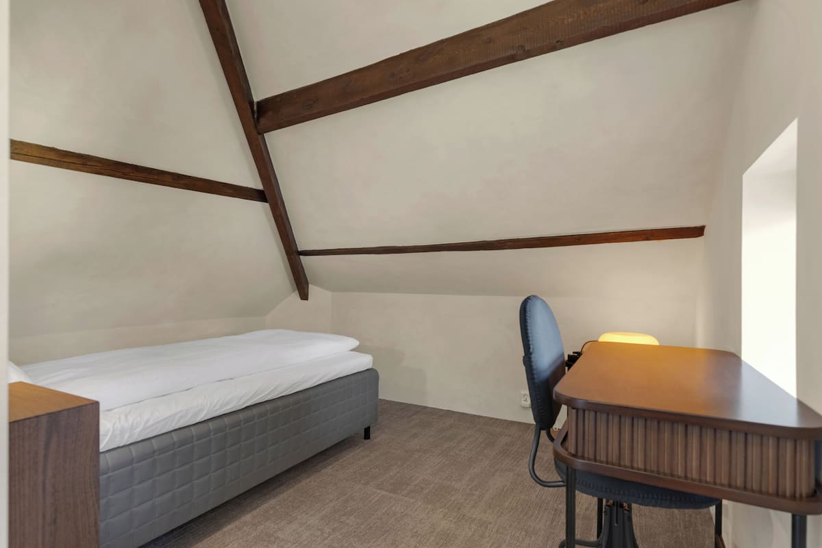Une chambre à coucher avec un lit, un bureau et une chaise.