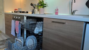 A modern kitchen with a dishwasher, a sink, and a countertop with a plant and a soap dispenser. - "Home from Home" with outdoor spaces for eating and relaxing, 5 minutes from the sea. (Tortoreto)