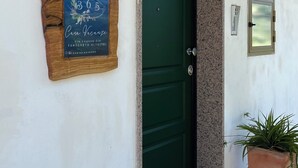 A green door with a plaque, a potted plant, and a number sign. - "Home from Home" with outdoor spaces for eating and relaxing, 5 minutes from the sea. (Tortoreto)